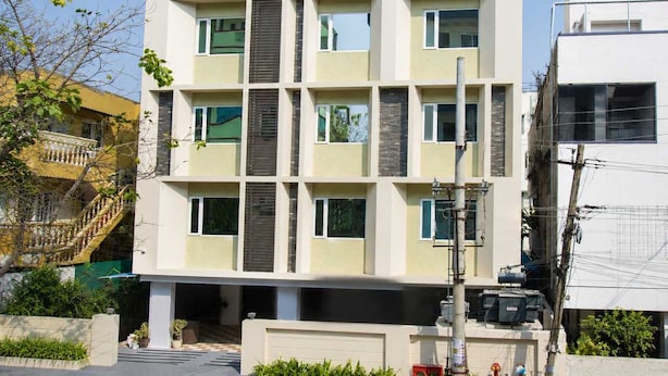 Um edifício residencial de vários andares com fachada simétrica, grandes janelas e telhado plano.