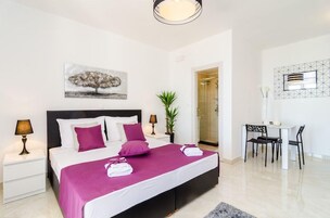 A bedroom with a bed, bedside tables, a desk, and a chair.