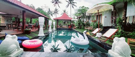 A swimming pool with lounge chairs and a gazebo.