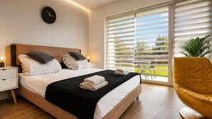 Ein modernes Schlafzimmer mit einem Bett, einem Nachttisch und einer Wanduhr.