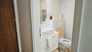 Ein modernes Badezimmer mit Waschbecken, Spiegel und Toilette.