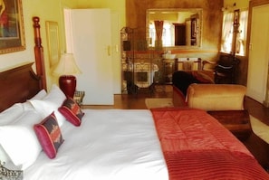 A hotel room with a bed, a desk, a chair, and a mirror. - Fox and Squirrel (Dullstroom)