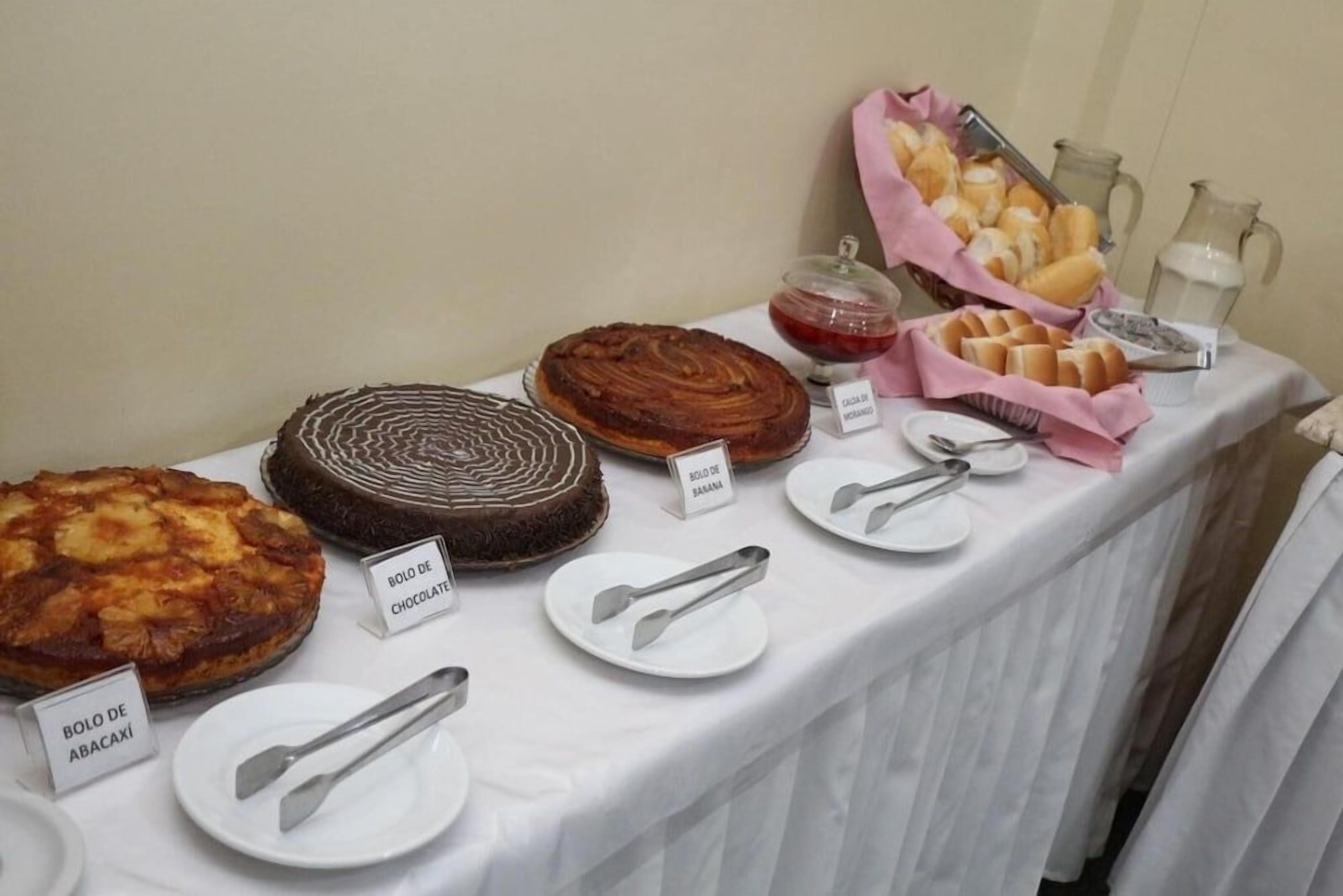 Mesa de buffet com diversos doces e um jarro de leite.