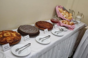 Una mesa de buffet con diversos postres y una jarra de leche.
