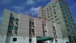 Ein Gebäude mit einem Schild, auf dem 'PLAZAHOTEL' steht, das ein Hotel kennzeichnet.