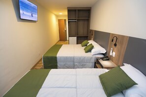Habitación de hotel con dos camas, televisión, escritorio con teléfono y armario.
