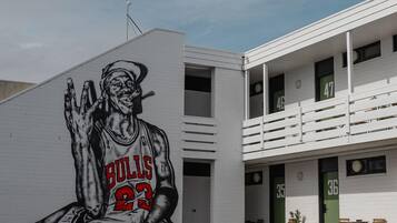 A building with a mural of a basketball player, balconies, and doors numbered 35 and 36.