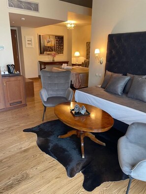 Una sala de estar moderna con un sofá, sillones, una mesa de centro y un comedor con una mesa y sillas.