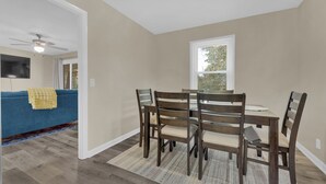 A dining area with a table and four chairs, a ceiling fan, and a window with blinds. - Newly Renovated, "Daisy" 3 Bedroom, 2 Bath Home! (Hanceville)