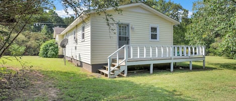 A small, single-story house with a front porch and a satellite dish.