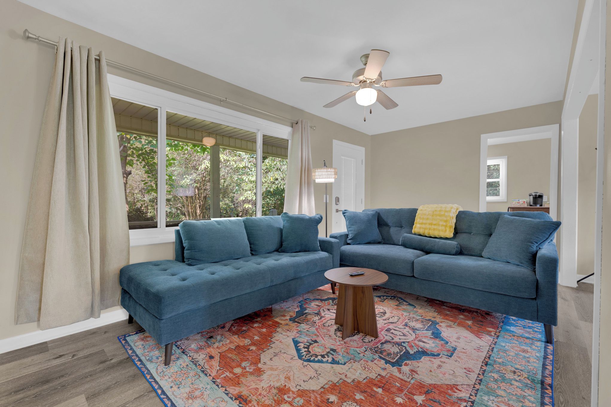 A living room with a sectional sofa, a coffee table, and a patterned rug.