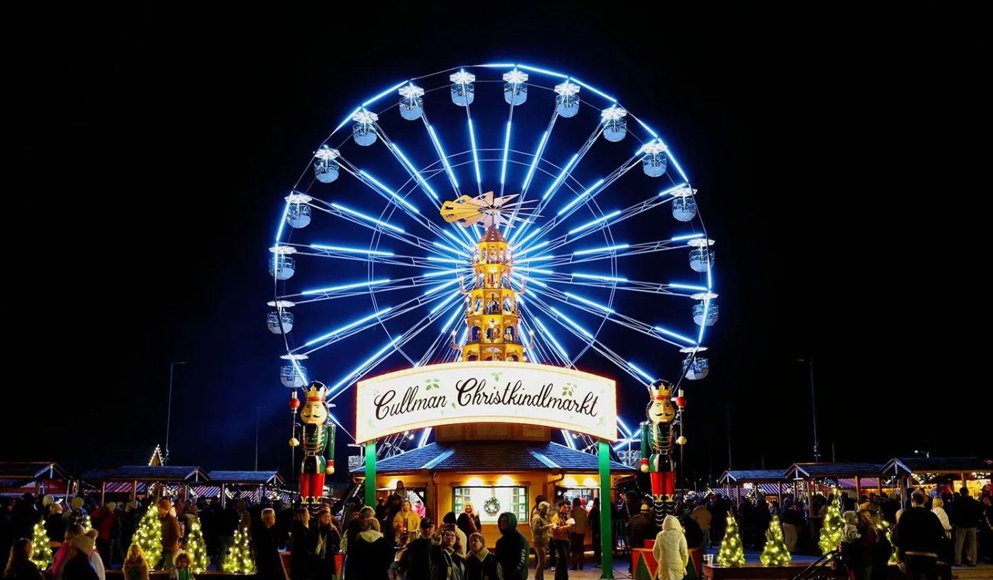 Une grande roue sur laquelle est affiché le panneau « Culman Christkindlmarkt » et des statues de casse-noisettes.