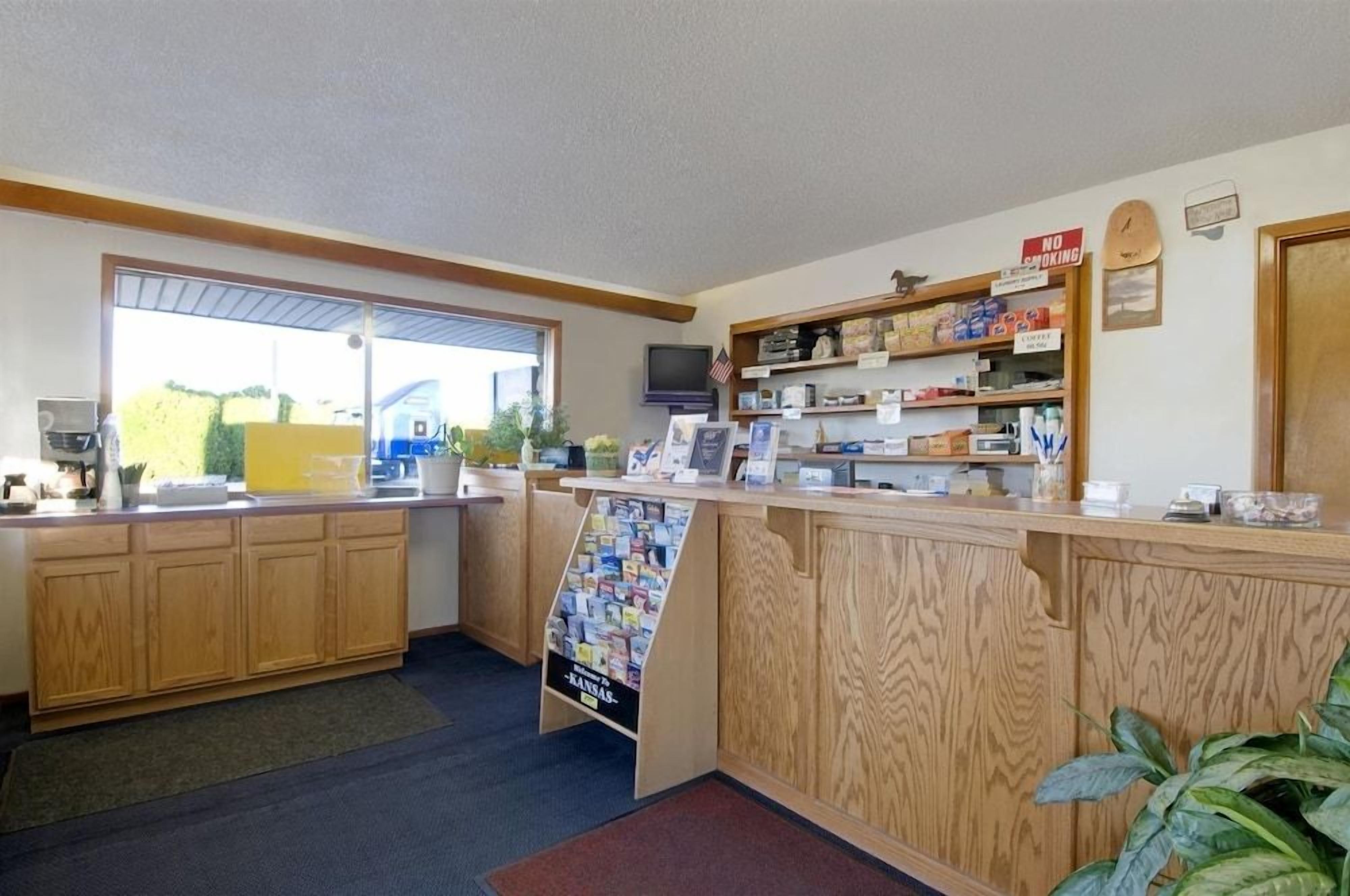 A reception area with a wooden counter, a television, and a sign indicating no cooking.