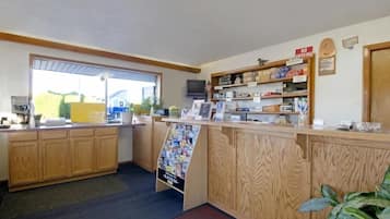 A reception area with a wooden counter, a television, and a sign indicating no cooking.