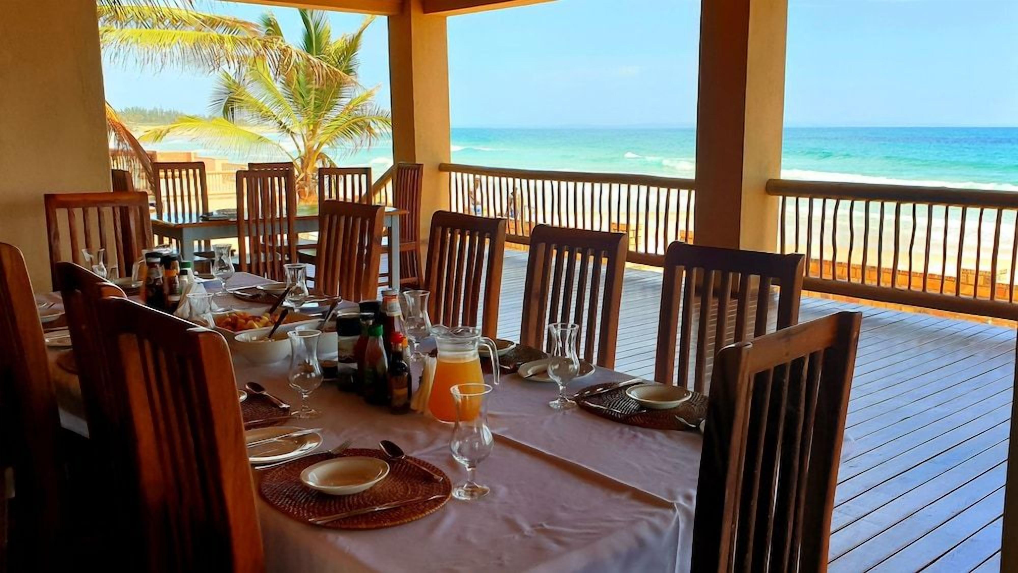 Une table à manger dressée pour quatre personnes, avec vue sur l’océan.