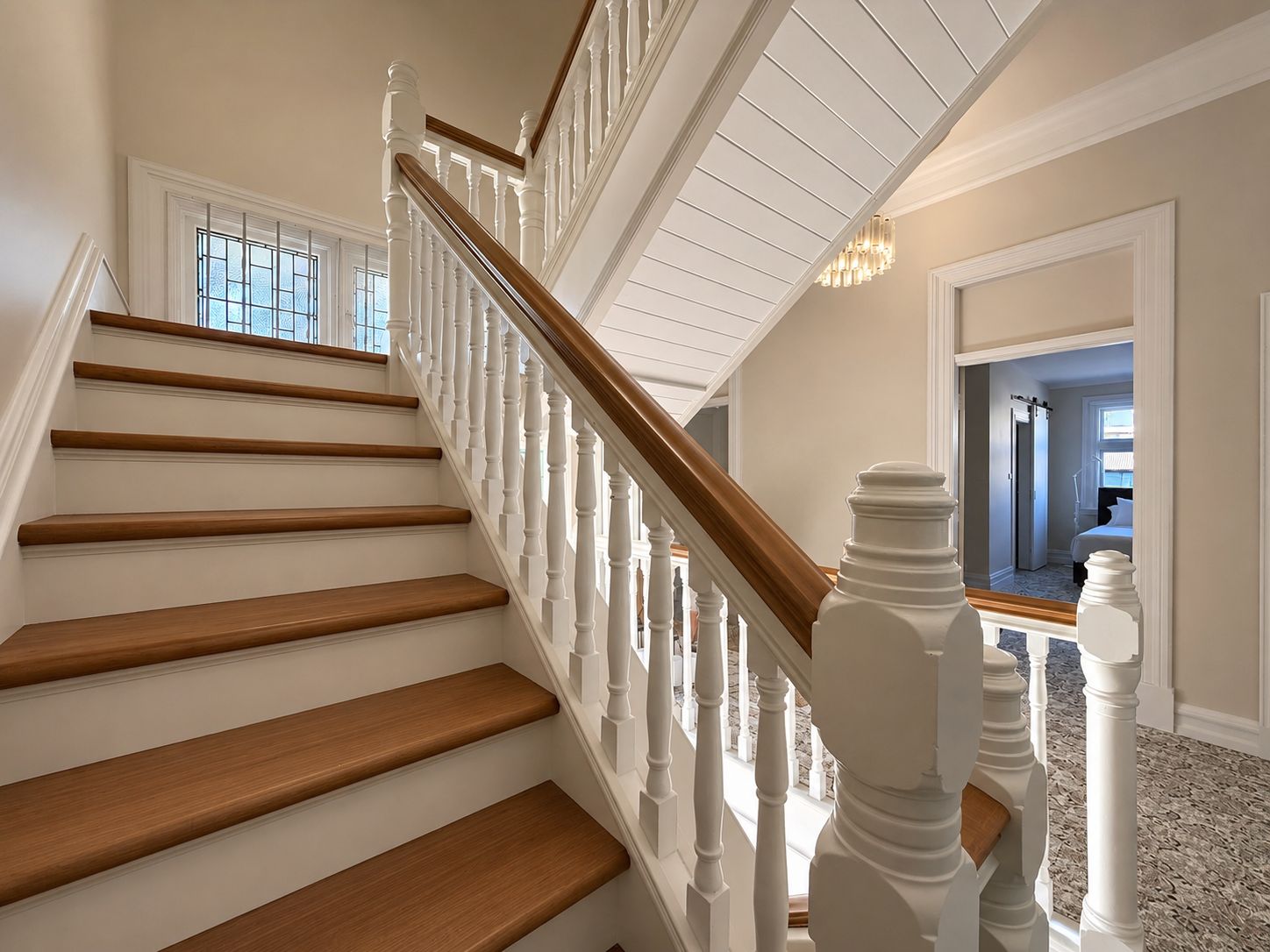 A staircase with white balusters and wooden steps leading to a landing.