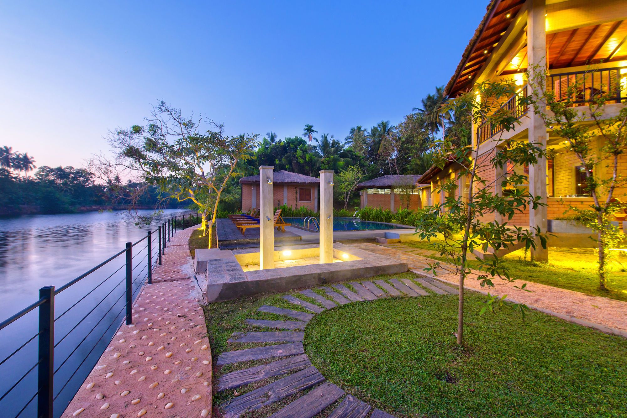 A resort with a pool, wooden deck, and a view of the water.