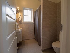 Un baño con ducha, inodoro y lavabo.