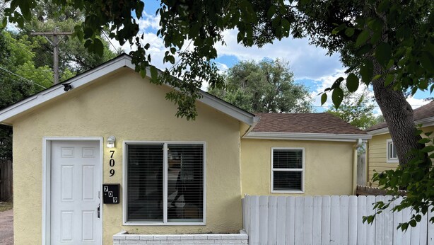 A single-story house with a white door, a mailbox, and a small window. - Perfect 1-bed house near downtown and Garden of the Gods Pet Friendly (Colorado Springs)