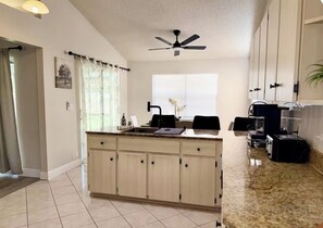 A kitchen with a central island, a ceiling fan, and cabinets. - Spring Hill Stay 
Pool, Games & Relaxation (Spring Hill)