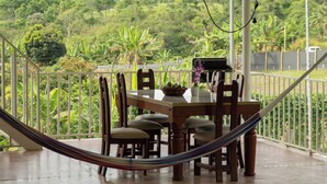 Eine Terrasse im Freien mit Tisch, Stühlen und einer Hängematte.