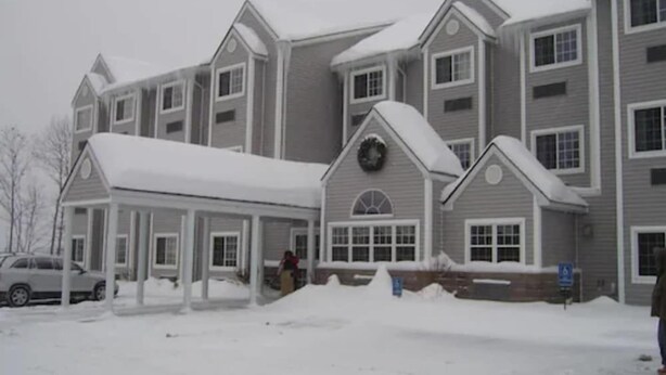 A multi-story building with a covered entrance and a snow-covered ground. - Microtel Inn By Wyndham Parry Sound (Parry Sound)