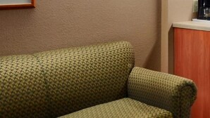A green patterned sofa with a wooden table in front. - Microtel Inn By Wyndham Parry Sound (Parry Sound)