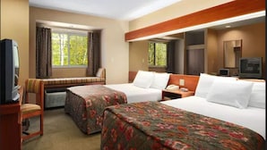 A hotel room with two beds, a desk, a chair, a television, and a window with curtains. - Microtel Inn By Wyndham Parry Sound (Parry Sound)