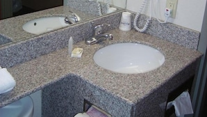 A bathroom with two sinks, a mirror, and two hair dryers mounted on the wall. - Microtel Inn By Wyndham Parry Sound (Parry Sound)