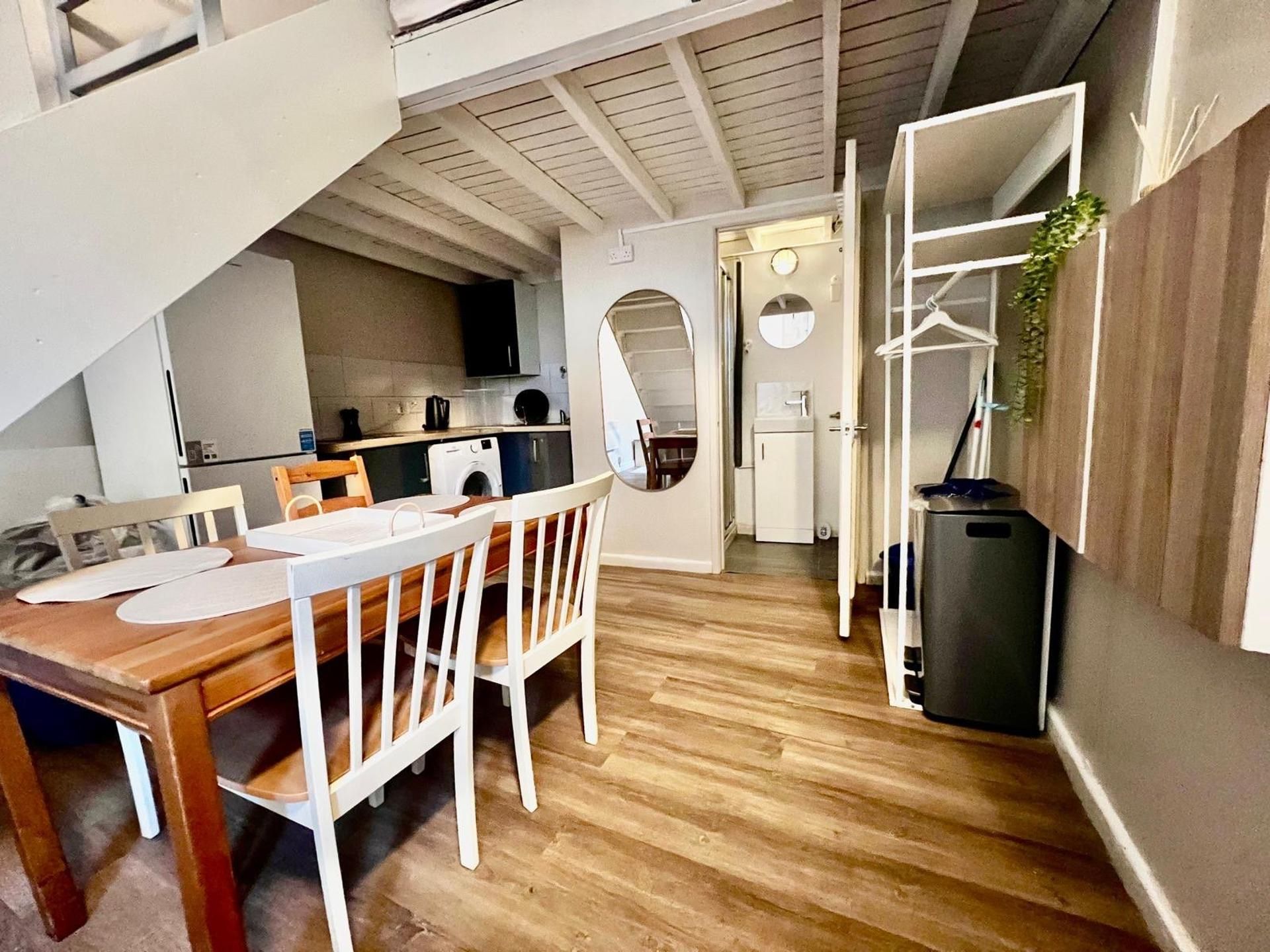 A compact living space with a dining area, kitchenette, and a small entryway.