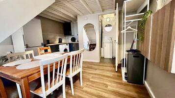 A compact living space with a dining area, kitchenette, and a small entryway.