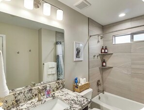 A modern bathroom with a marble sink, a large mirror, a shower, and a toilet. -  Havasu Palisades - Lake Days & Sunset Nights- Modern  Retreat - Sleeps Seven (Lake Havasu City)