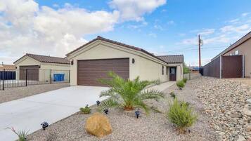 A residential property with a garage, a driveway, and a landscaped front yard with rocks and small plants.