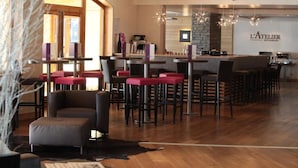 Interior de restaurante com área de bar, assentos e balcão.