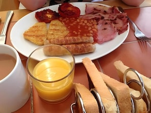 Un plato con huevos, frijoles, tomates y jamón.