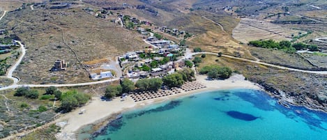Un pueblo costero con playa, aguas azul turquesa y campos en terrazas.