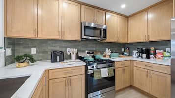 A modern kitchen with wooden cabinets, a stainless steel range, a microwave, and a stove.