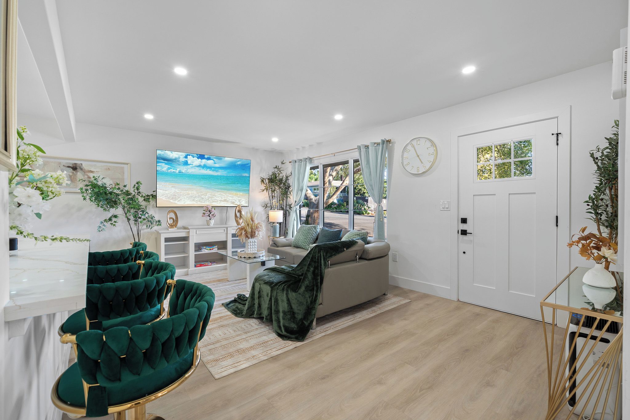A modern living room with a sofa, a TV, and a dining area with a table and chairs.