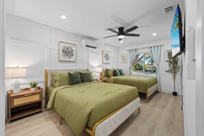 A hotel room with two beds, a ceiling fan, artwork on the walls, and a window with curtains. - Gated Yard, King Bed, Parking, Ranch-Style La Mesa (La Mesa)