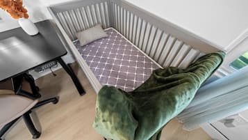 Habitación de esquina con cama, mesa y silla.