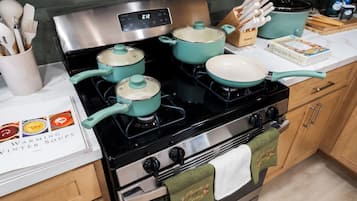 Una cocina con estufa, ollas y un libro de cocina titulado 'WARMING VINTER SOUPS'.