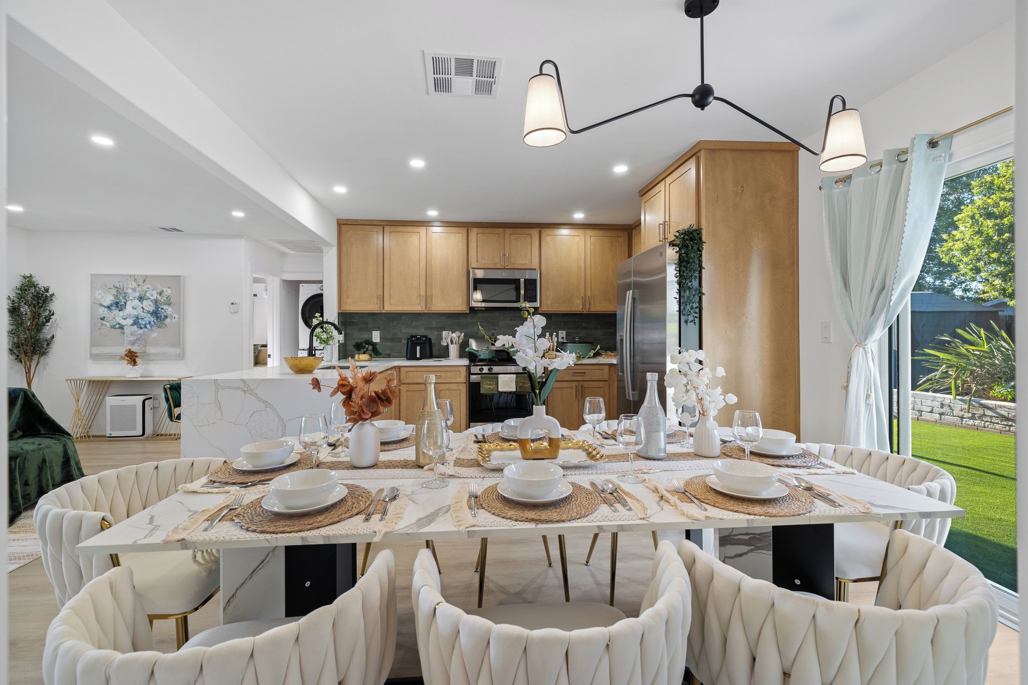 Una cocina moderna con armarios de madera, electrodomésticos de acero inoxidable y un comedor listo para disfrutar de una comida.