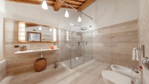 A modern bathroom with a glass-enclosed shower, a vanity with a mirror, and a bathtub. - Tenuta di Montecucco - Collemassari Hospitality (Cinigiano)