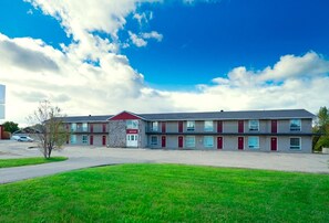 A two-story motel with a red roof, multiple windows, and a parking lot. - Save Inn Kincardine (Kincardine)