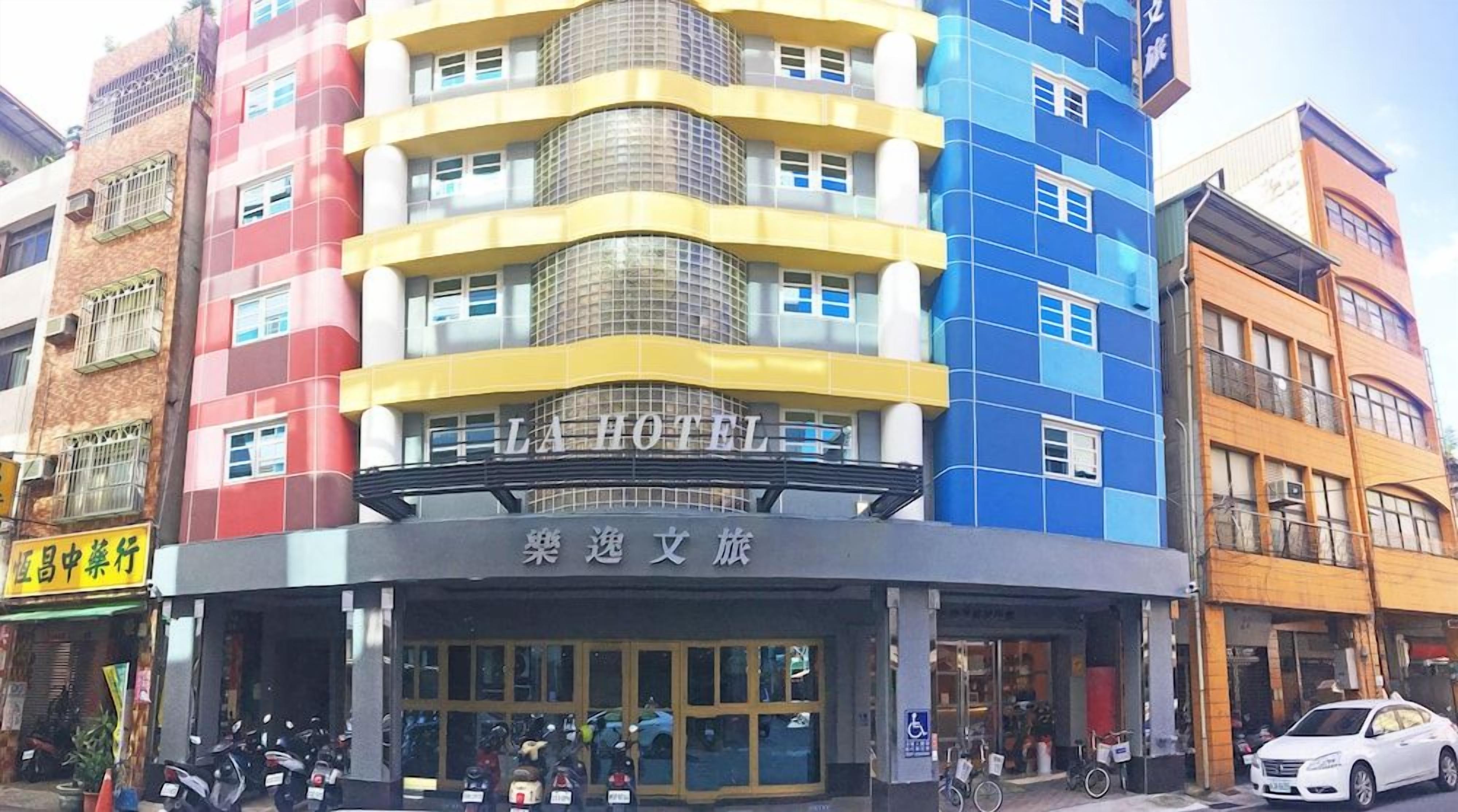 A multi-story hotel with a prominent sign reading 'LA HOTEL' and a sign in a foreign language below it.