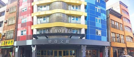 A multi-story hotel with a prominent sign reading 'LA HOTEL' and a sign in a foreign language below it.