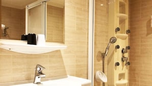 A modern bathroom with a glass-enclosed shower, a white sink, and a mirror above it. - Kindness Hotel Lio He Ye Shi (Kaohsiung)