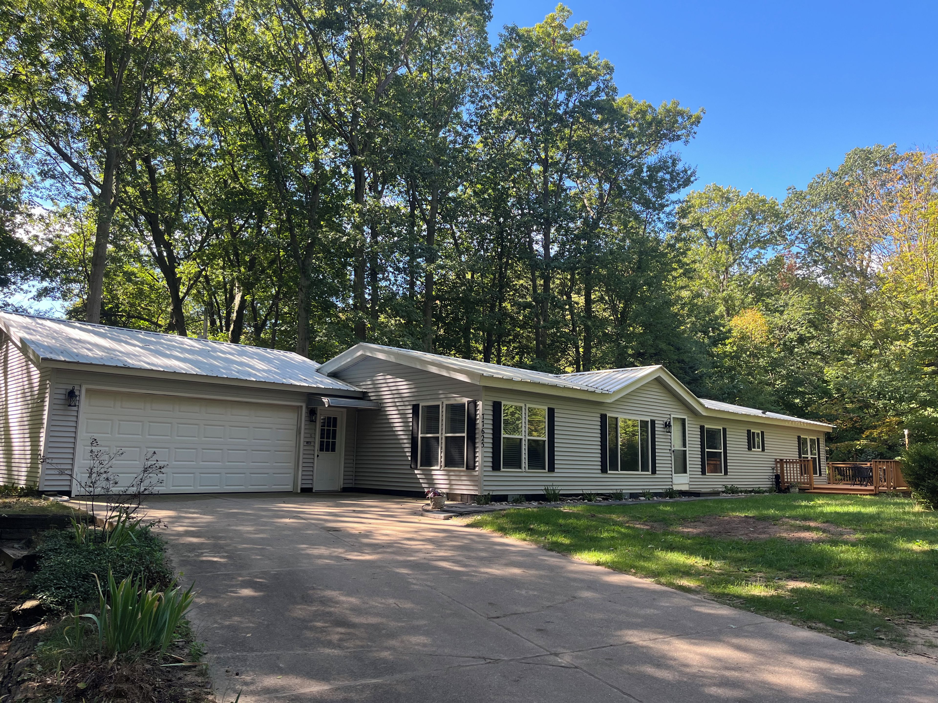 A two-story house with a garage, a covered porch, and a well-maintained lawn.