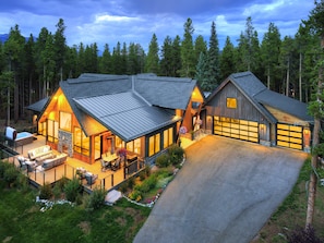 A two-story cabin with a deck, a hot tub, and a garage. - NEW Trailblazer Lodge, the Ultimate Family Destination (Breckenridge)
