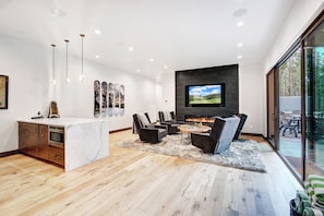 A modern living space with a kitchen, seating area, and a fireplace. - NEW Trailblazer Lodge, the Ultimate Family Destination (Breckenridge)